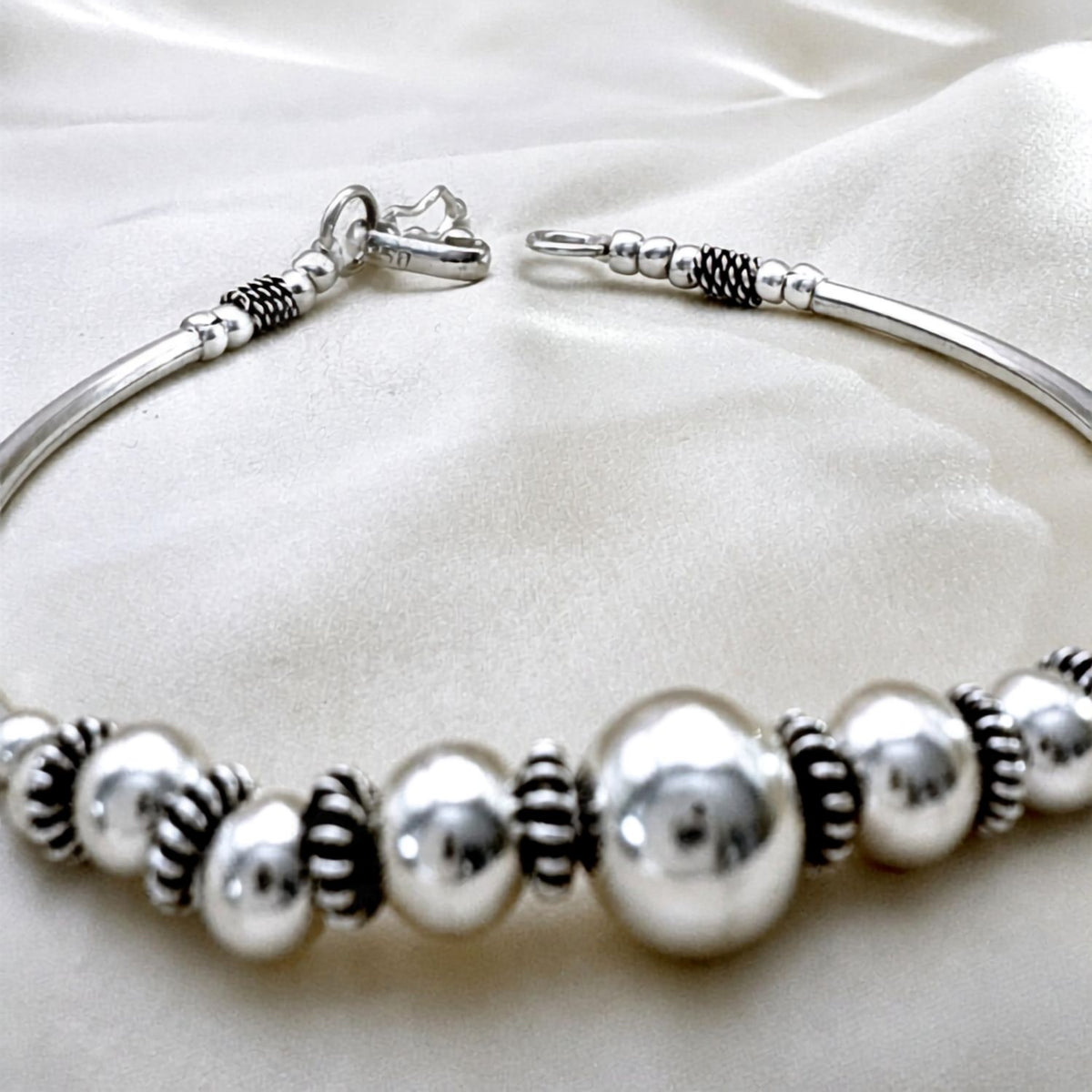Détail des sphères et finitions contrastées du bracelet jonc Sélia en argent