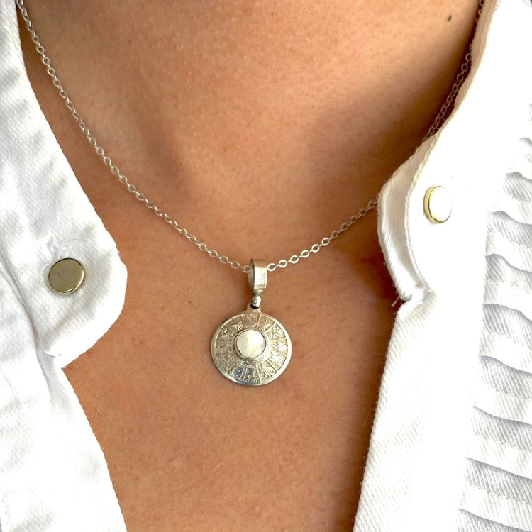 Pendentif artisanal en argent porté sur une chaîne de la collection Essentielle Cholita Nova