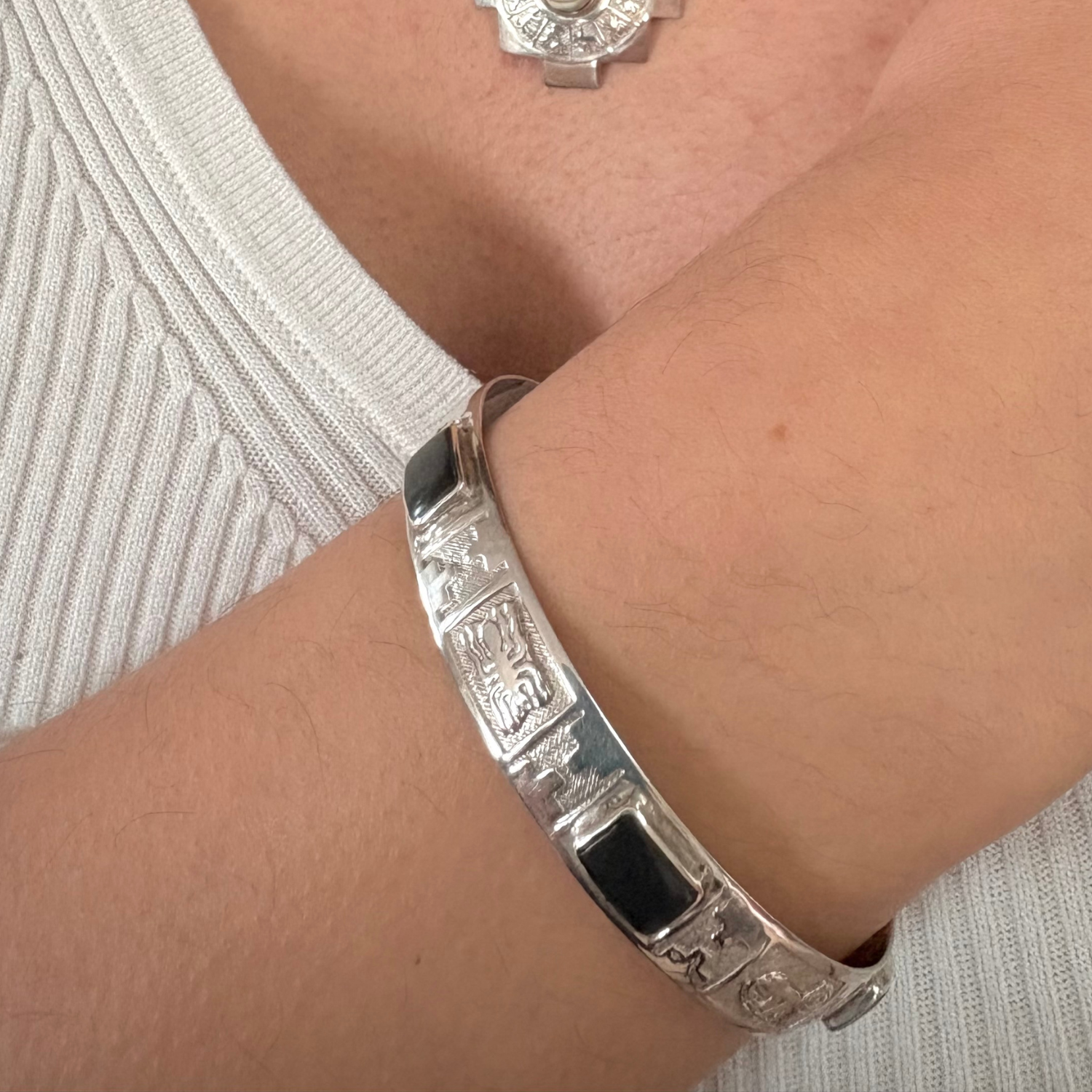 
ALT TEXT :Manchette contemporaine en argent portée au poignet 
