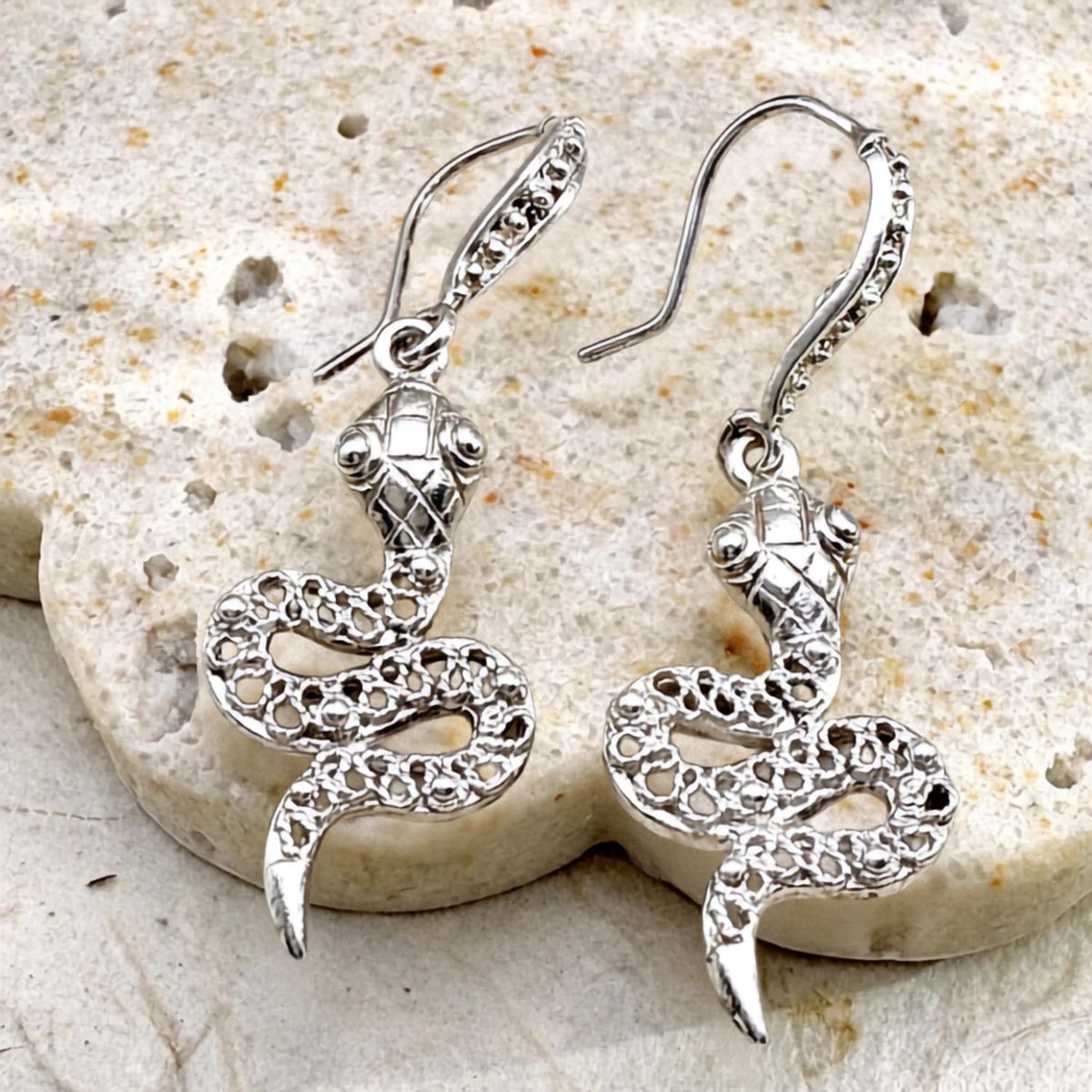 Boucles d'oreilles Ondine en argent représentant un serpent au design ajouré, vue de face.