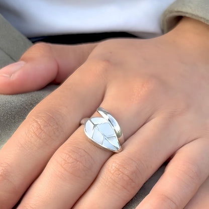 Bague Vita portée au doigt en argent et nacre naturelle avec motif feuille.