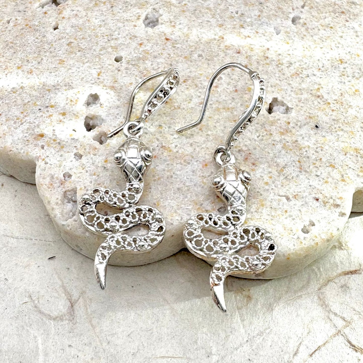 Boucles d'oreilles Ondine en argent représentant un serpent au design ajouré, vue de face.
