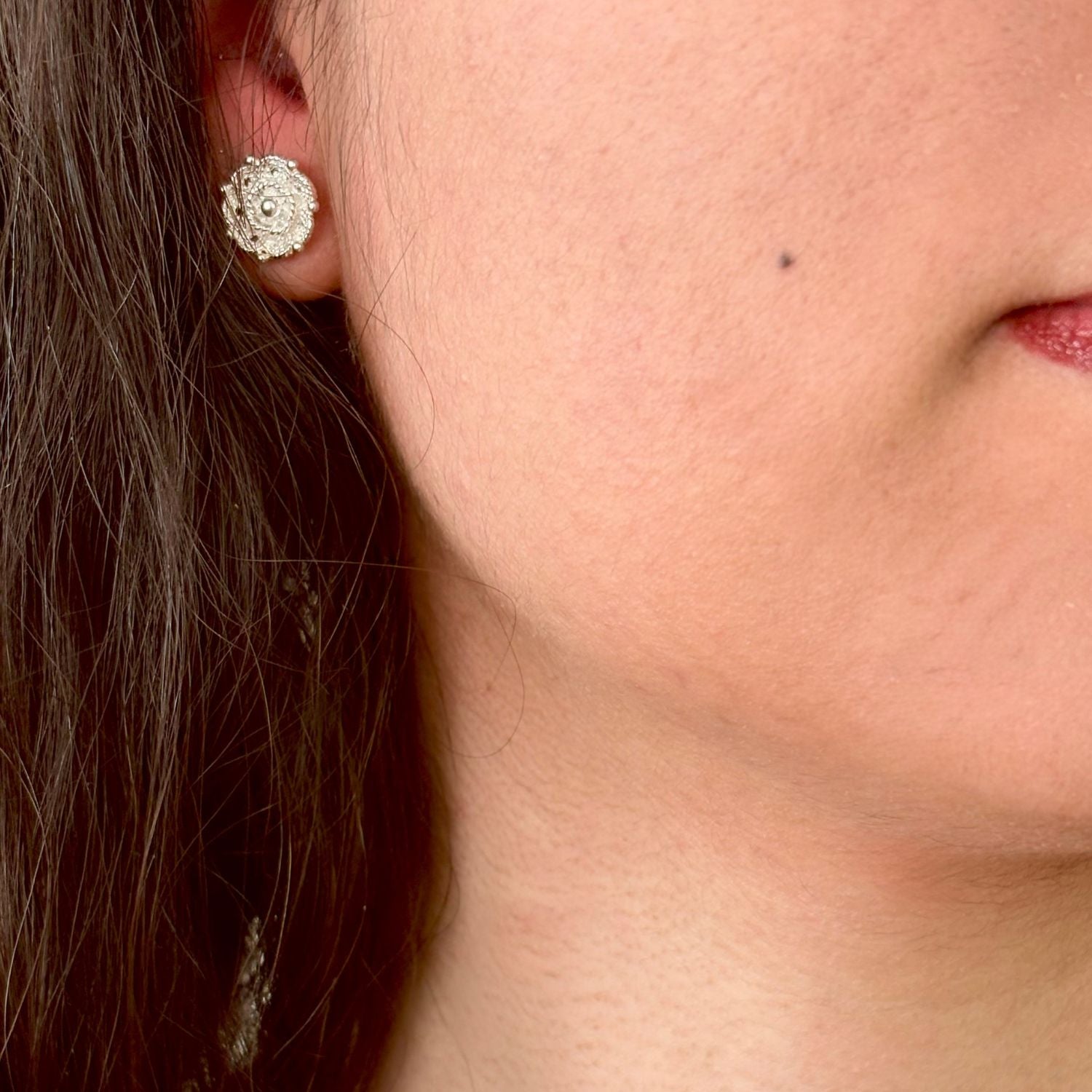 Boucles d'oreilles Roséa portées mettant en valeur leur format discret et leur motif floral ajouré.