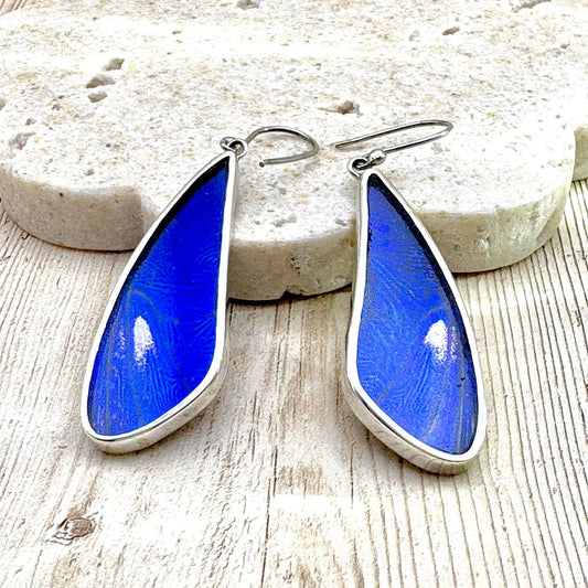 Boucles d'oreilles artisanales en argent et ailes de papillon bleu intense.