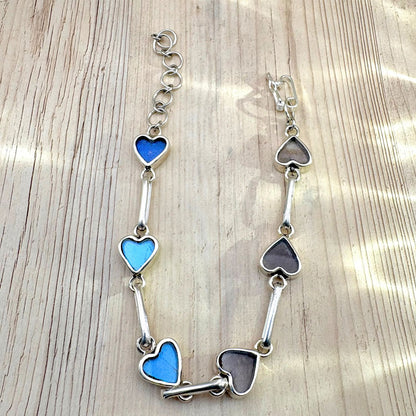 Bracelet Aelya révélant les nuances des véritables ailes de papillon, entre bleu irisé et tons naturels selon l'orientation des ailes 
