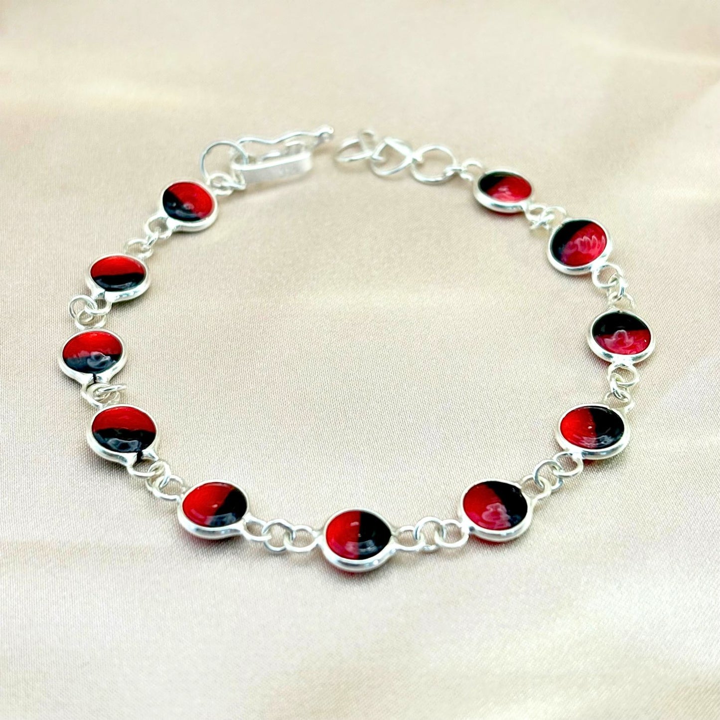 Bracelet Sumaq en argent avec graines naturelles de huayruro. Création artisanale de la collection Héritage.