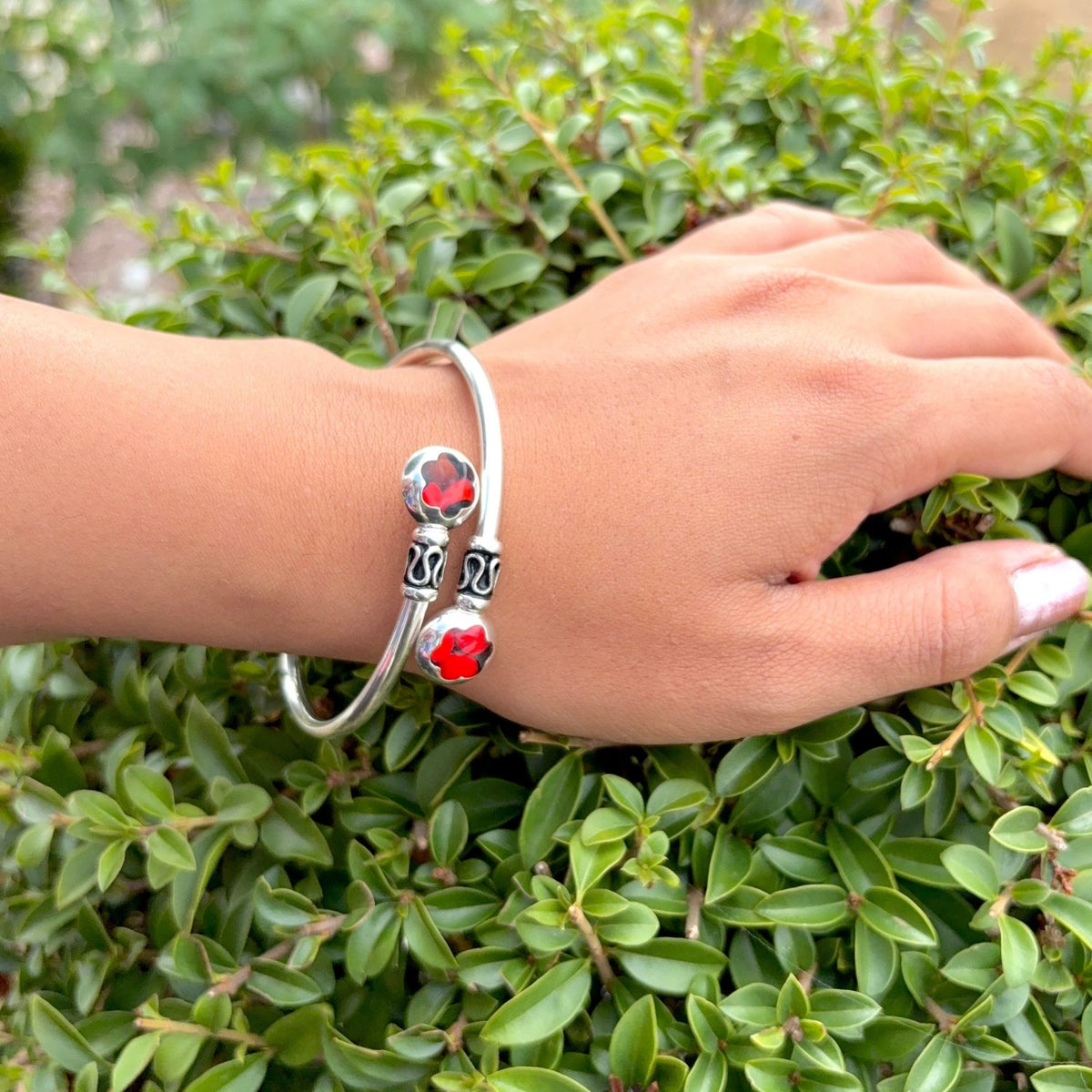 Bracelet jonc Huayruro modèle Fleur porté au poignet