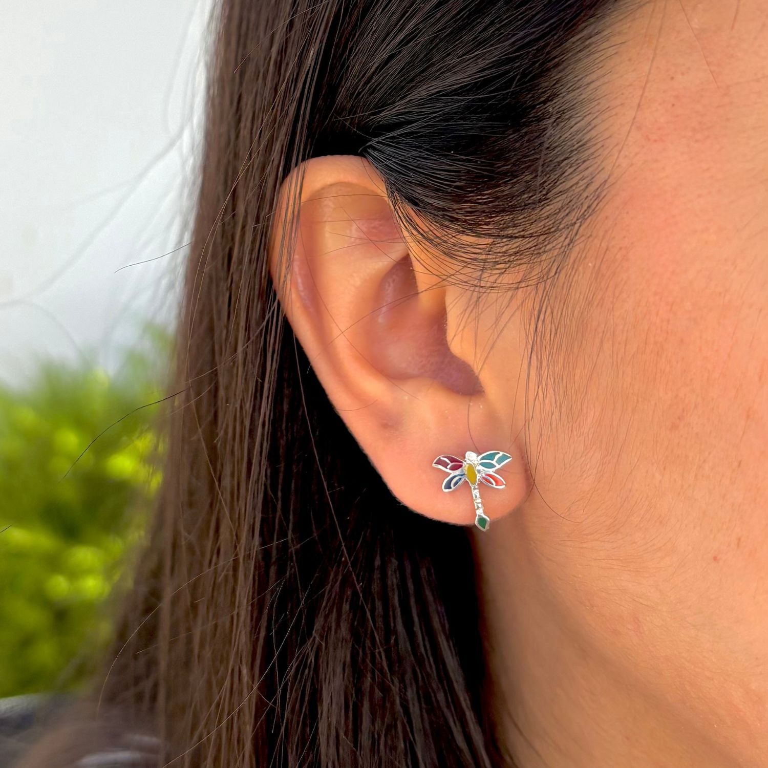 Clous d'oreilles Essentielle motif libellule portés à l'oreille.
