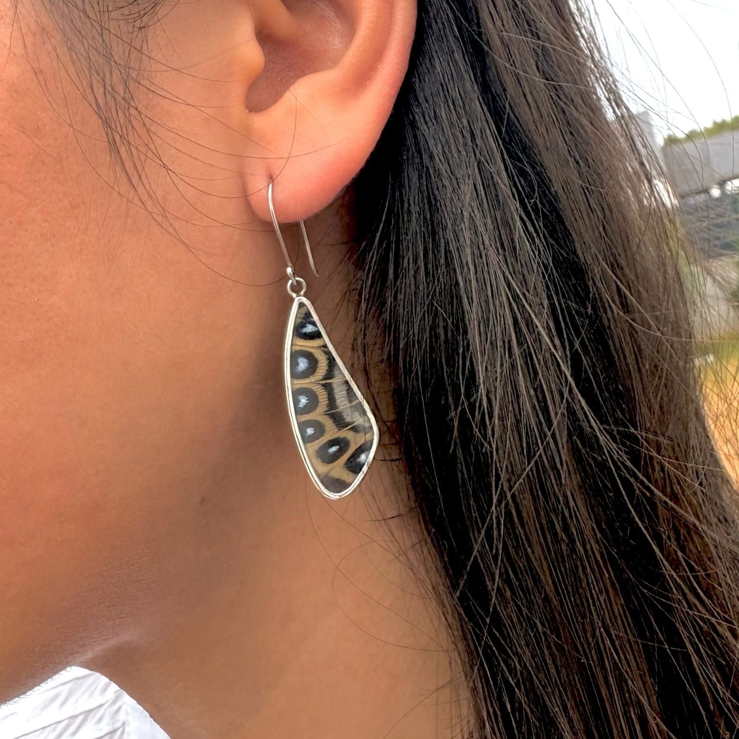 Grandes boucles d'oreilles Élyne en argent portées.