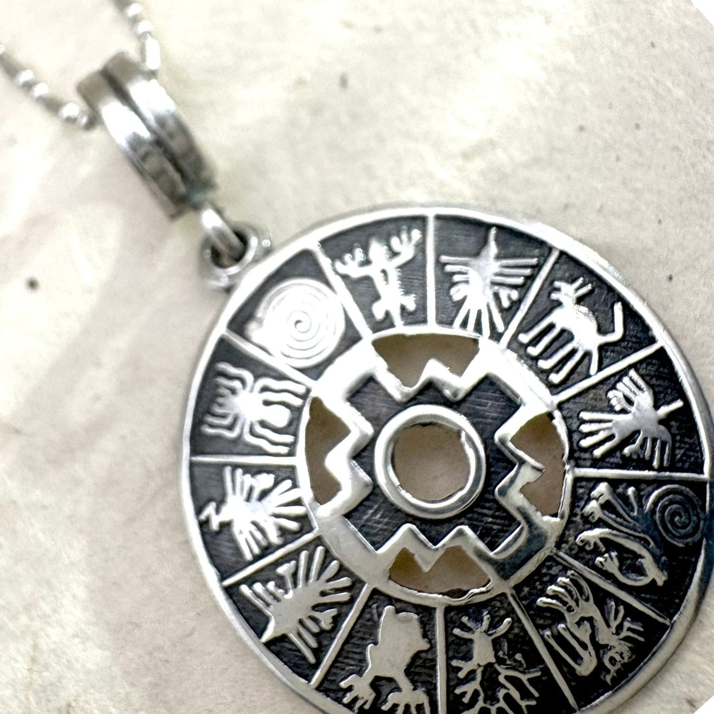 Gros plan du pendentif Chakana Essentielle mettant en valeur les détails du motif chakana.
