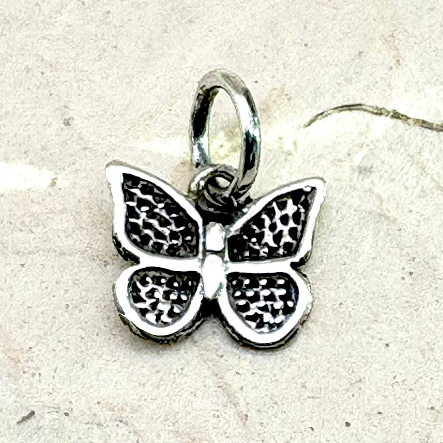 Gros plan du pendentif Papillon Ombre révélant les détails des ailes