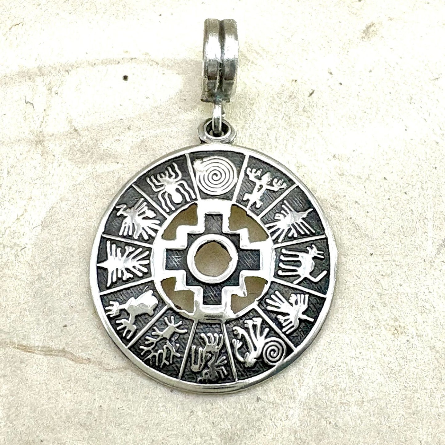 Pendentif Chakana Essentielle en argent oxydé avec motif chakana ajouré et cercle travaillé.