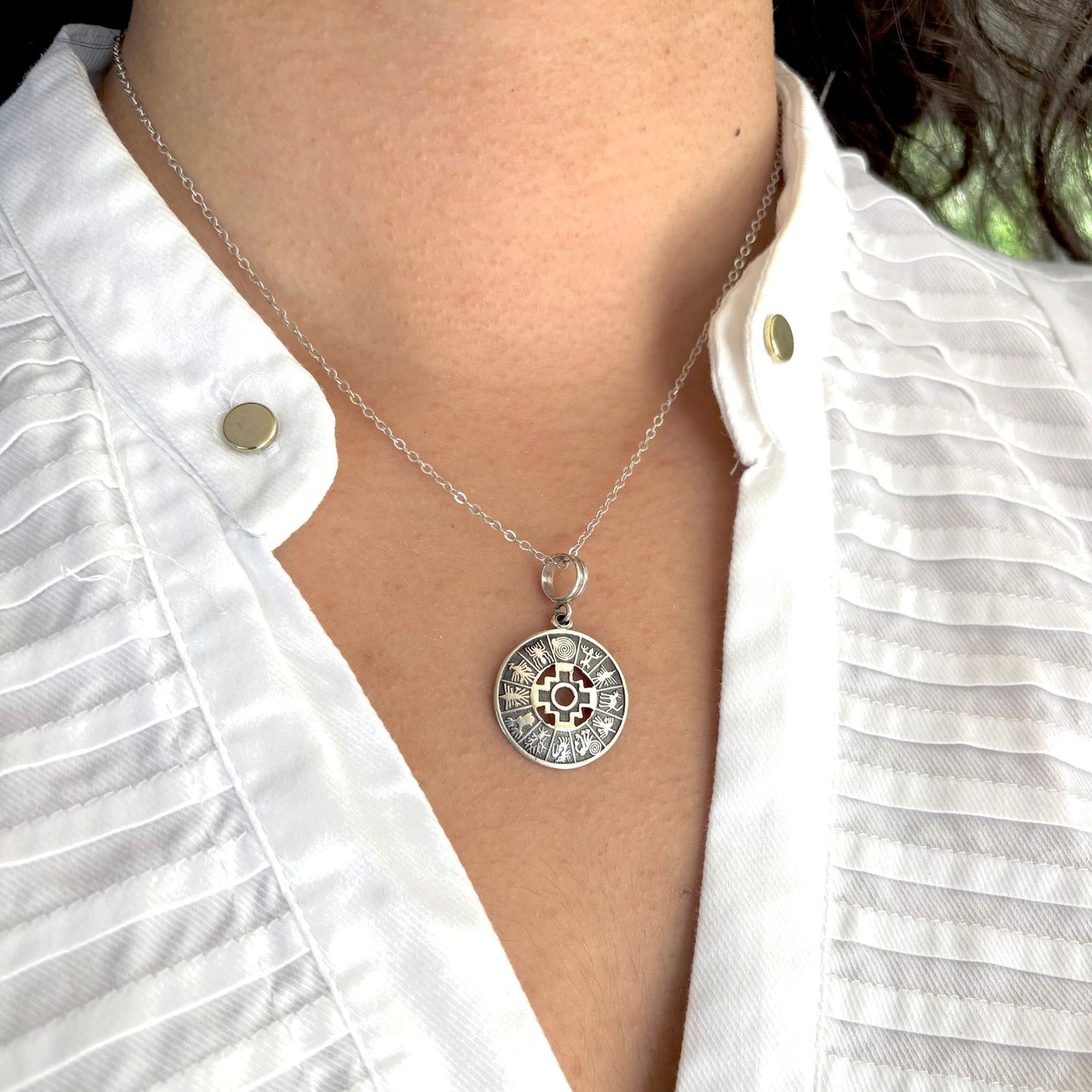 Pendentif Chakana Essentielle porté avec chaîne en argent. 