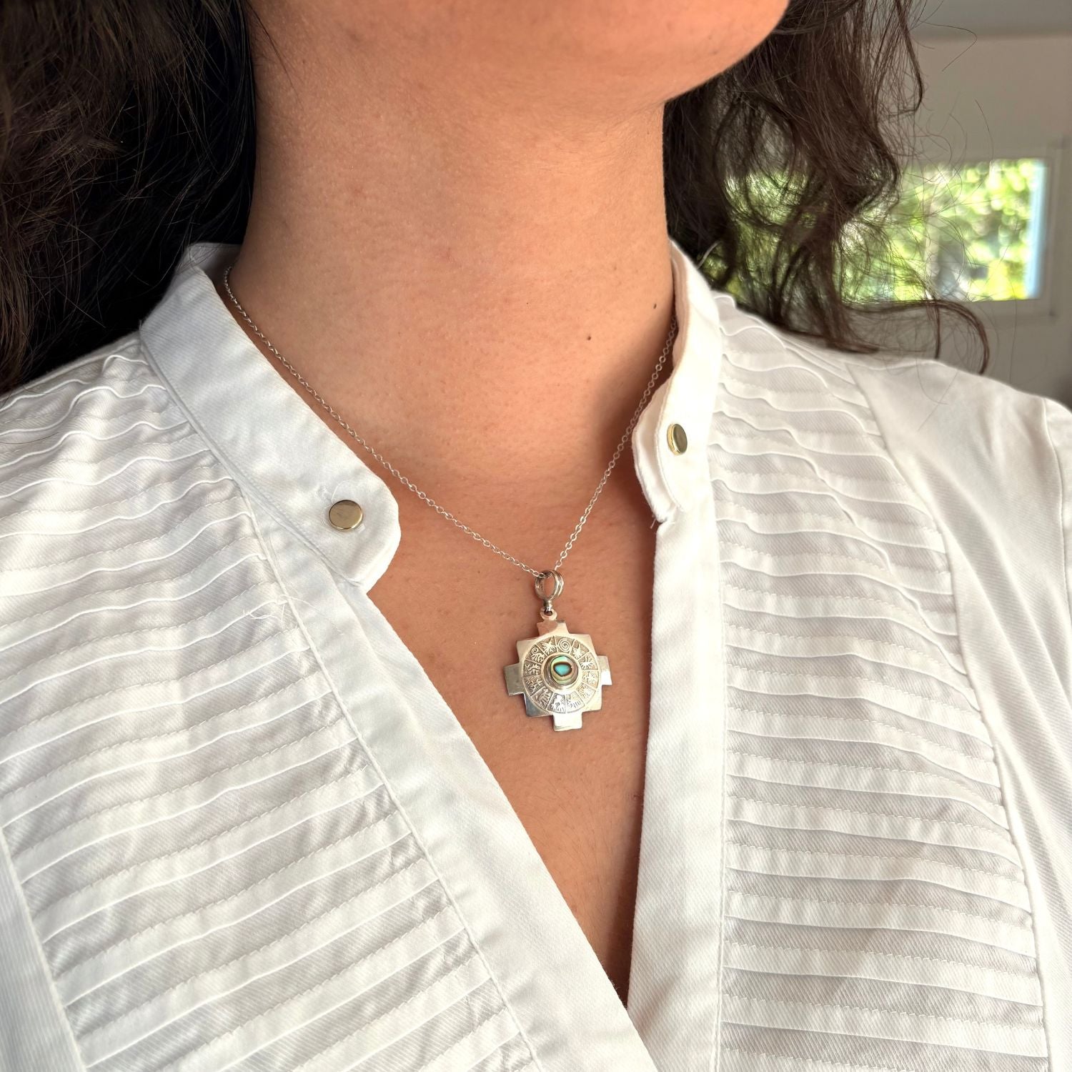 Pendentif Nexa porté avec une chaîne en argent, bijou artisanal élégant et contemporain.