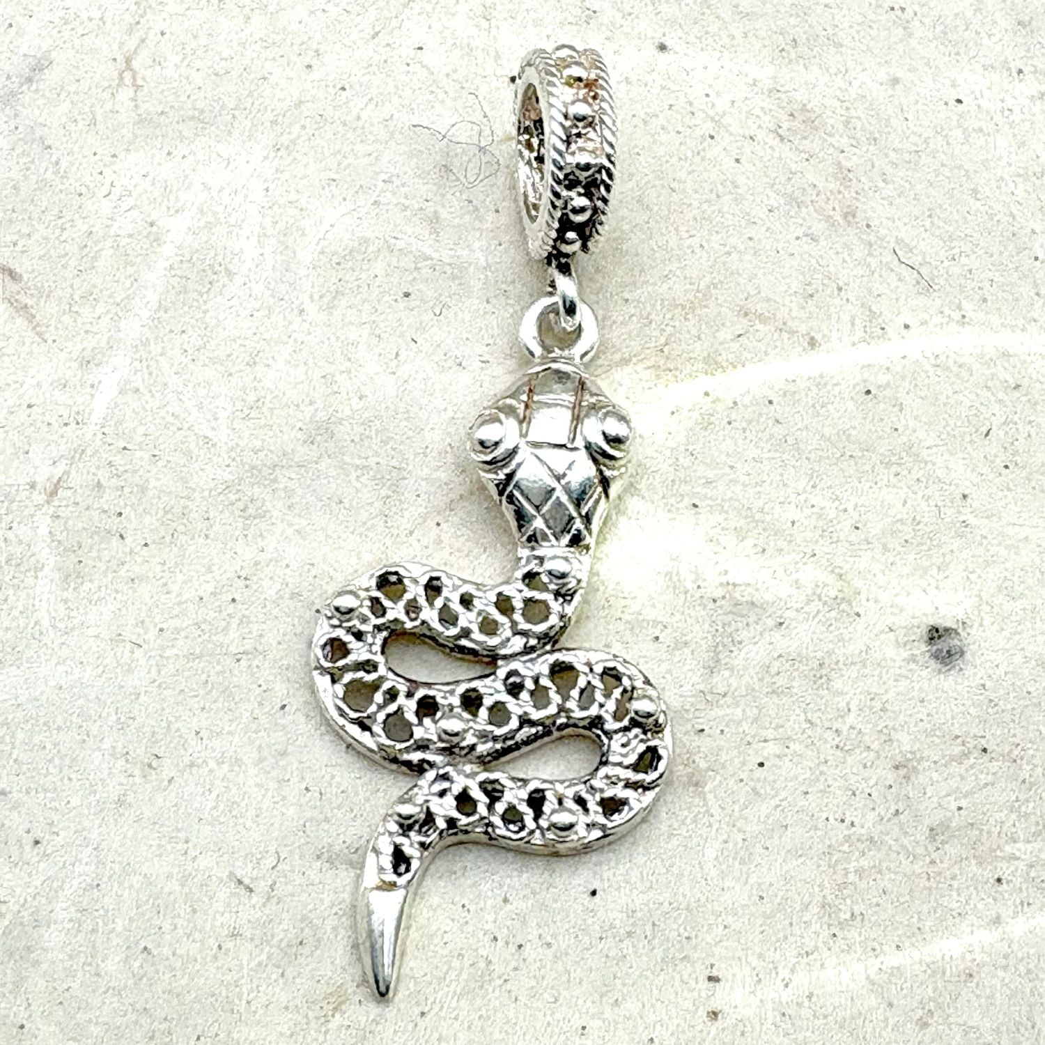 Pendentif Ondine en argent présenté sur fond clair, mettant en valeur ses courbes et son relief.