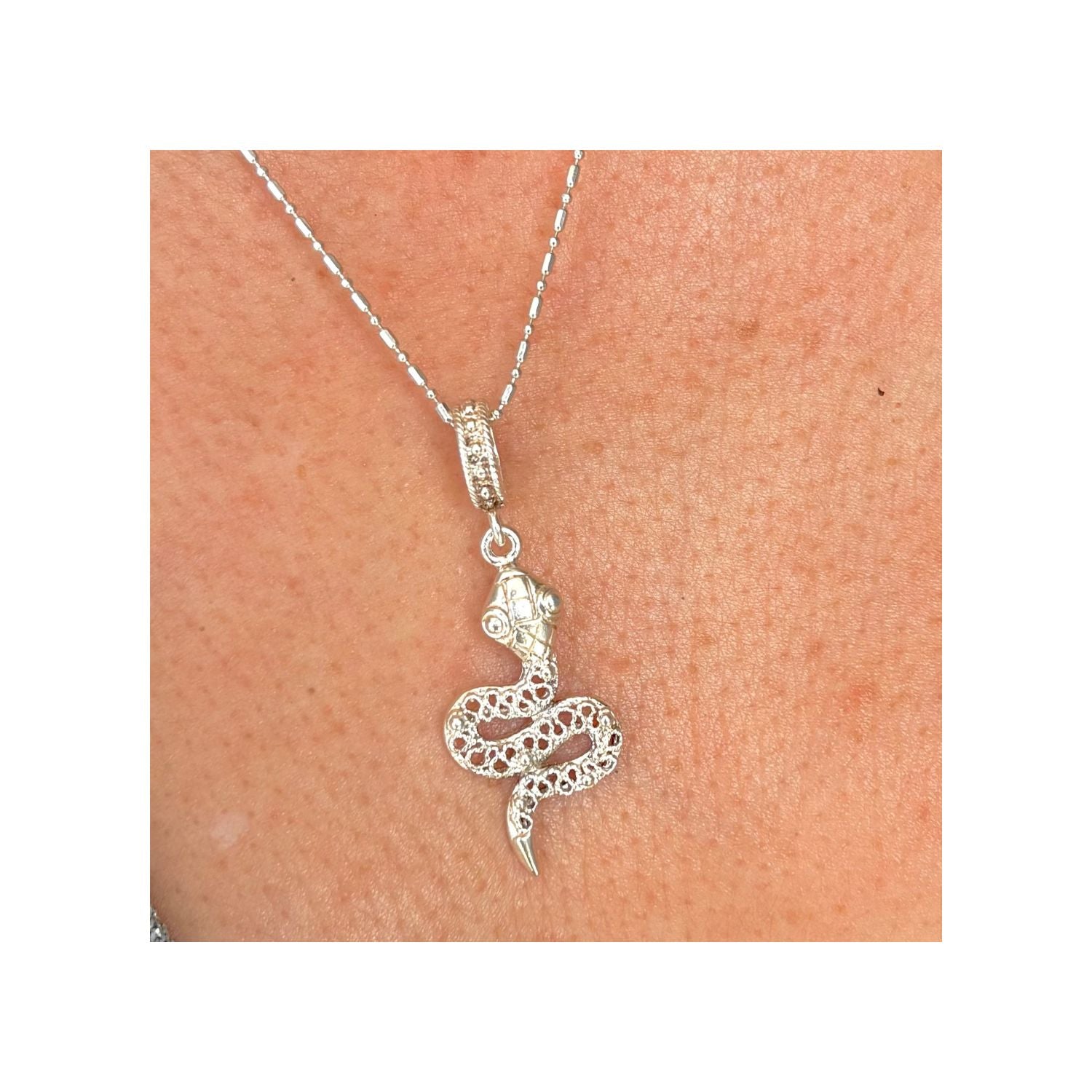 Pendentif Ondine en argent porté, vue rapprochée mettant en valeur le relief et les détails ajourés.