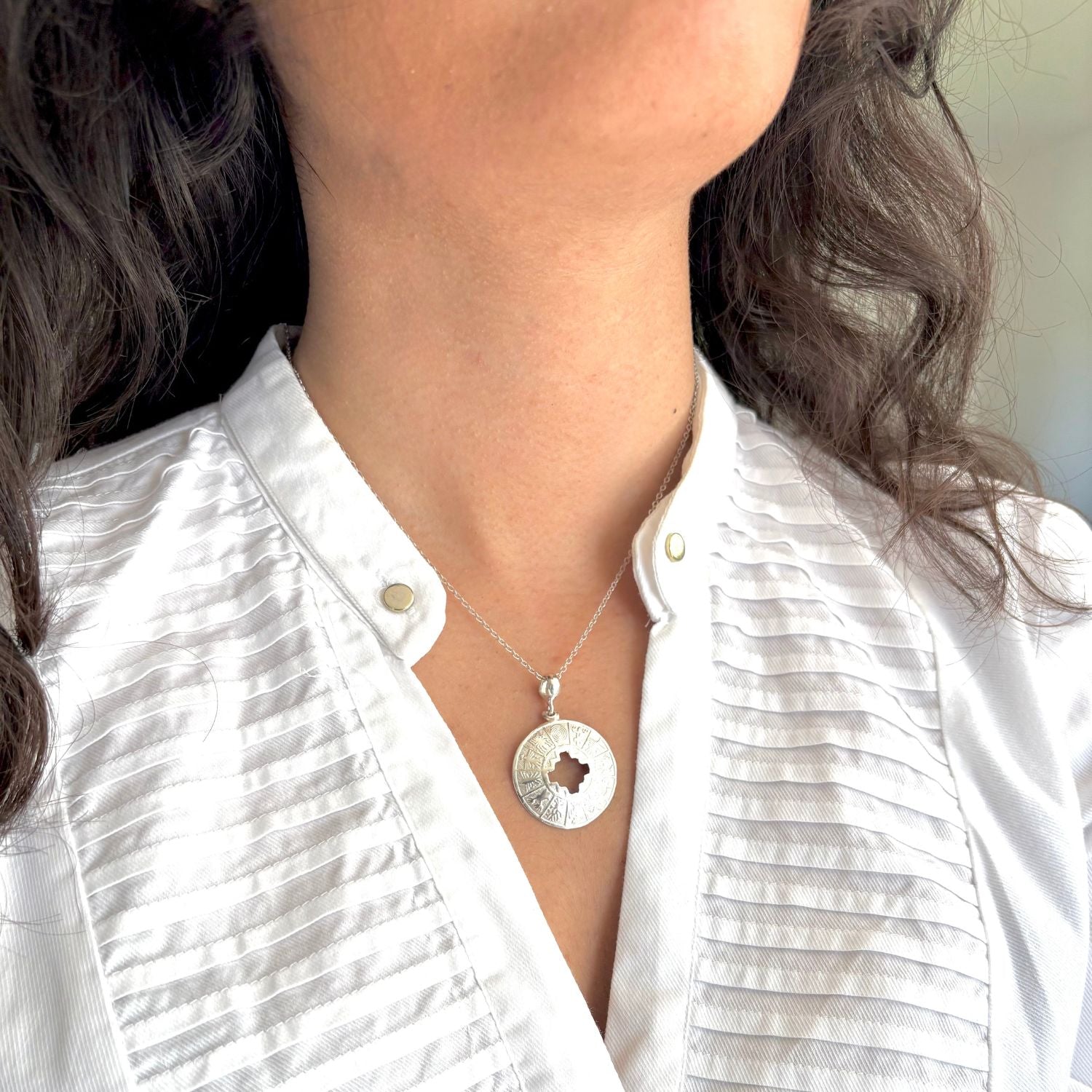 Pendentif Orizon porté avec une chaîne en argent.