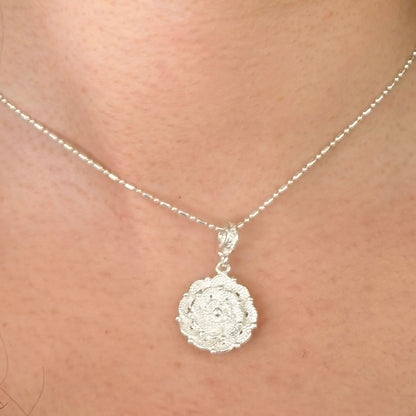 Pendentif Roséa porté mettant en valeur son motif floral  et sa finesse.