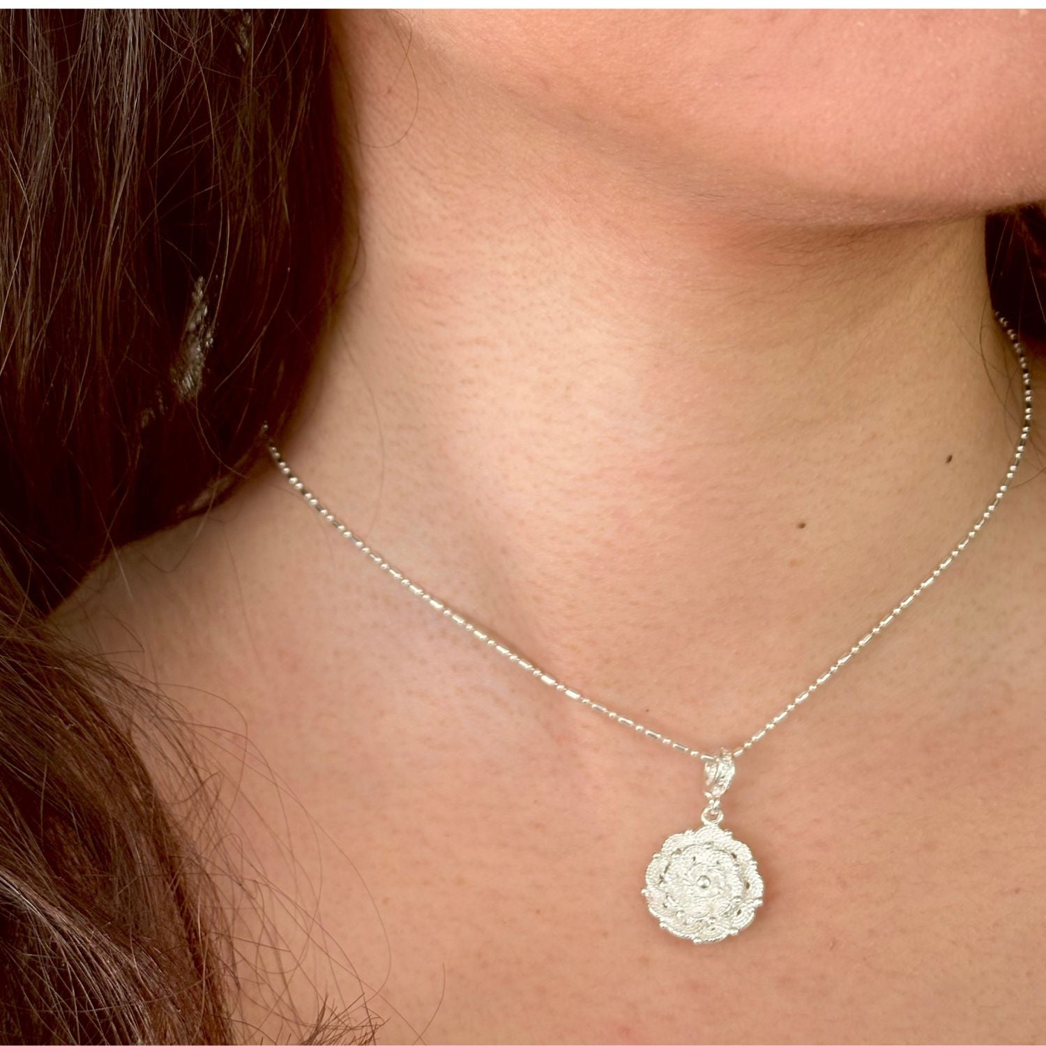 Pendentif Roséa porté avec chaîne en argent, création artisanale délicate de la collection Essentielle.