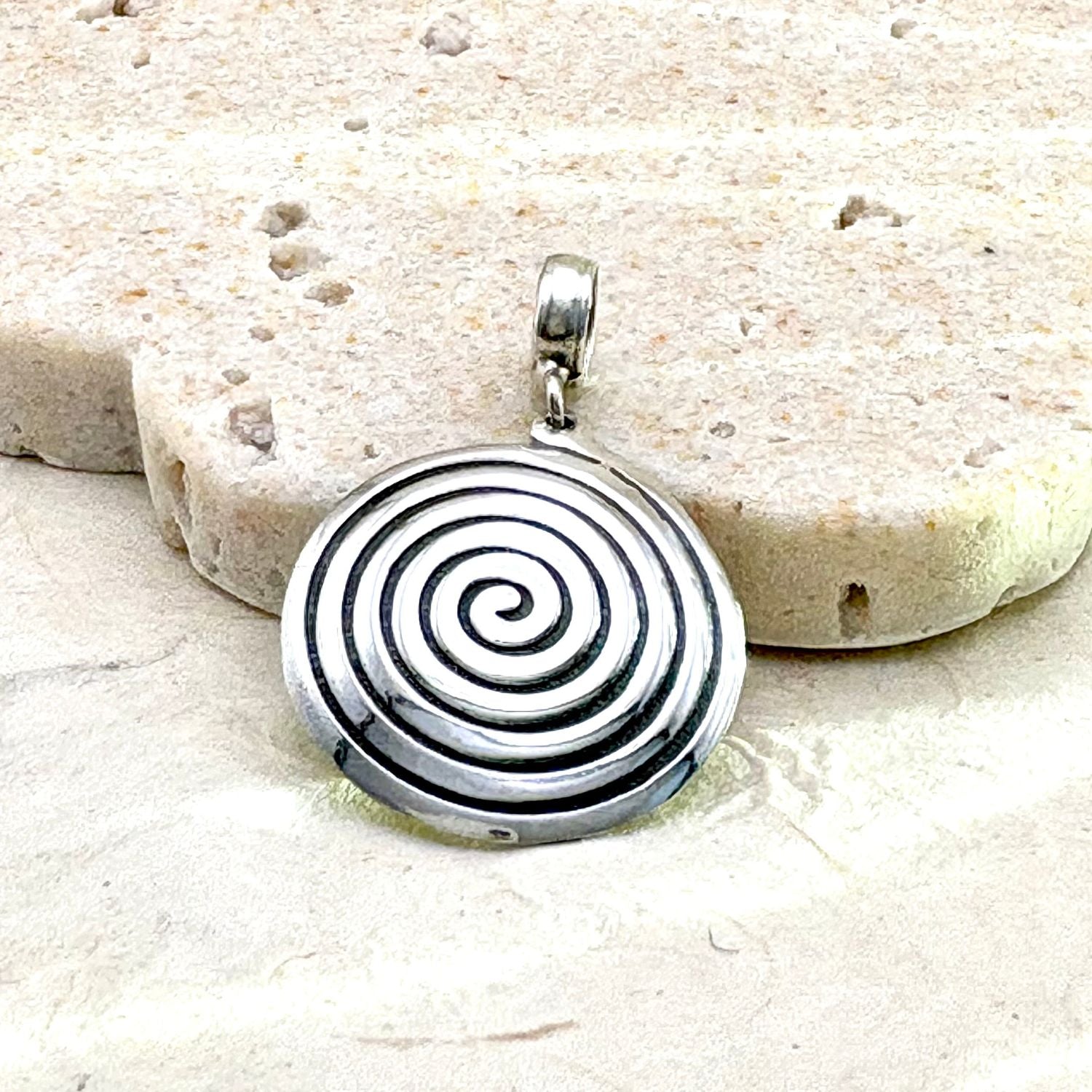 Pendentif Spira porté avec une chaîne en argent, bijou artisanal élégant et contemporain.