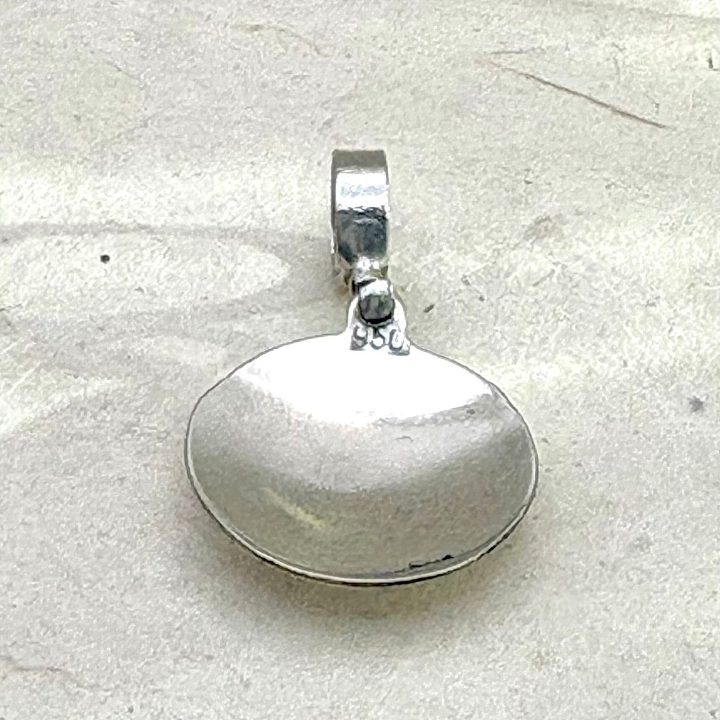 Vue arrière du pendentif Lumia en argent montrant les finitions artisanales du bijou.