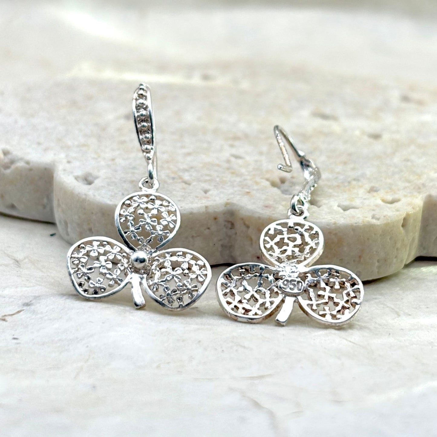 Vue avant et arrière des boucles d'oreilles Folia mettant en valeur les détails du travail artisanal et du fermoir.