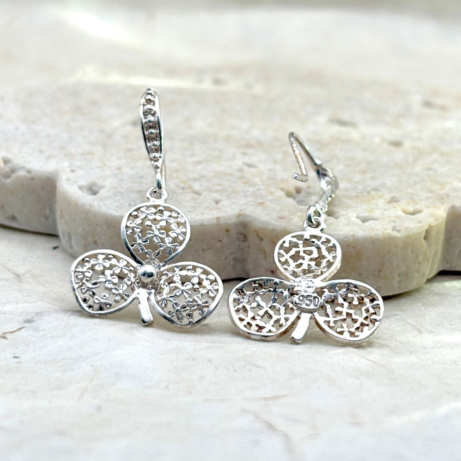 Vue avant et arrière des boucles d'oreilles Folia mettant en valeur les détails du travail artisanal et du fermoir.