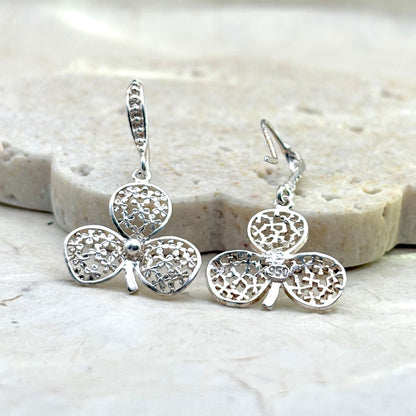 Vue avant et arrière des boucles d'oreilles Folia mettant en valeur les détails du travail artisanal et du fermoir.
