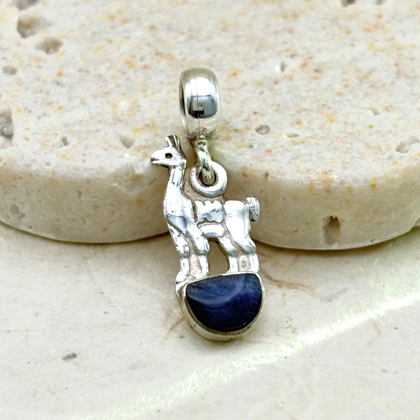 Vue rapprochée du pendentif Lama en argent mettant en valeur le lapis-lazuli et les détails de la silhouette.