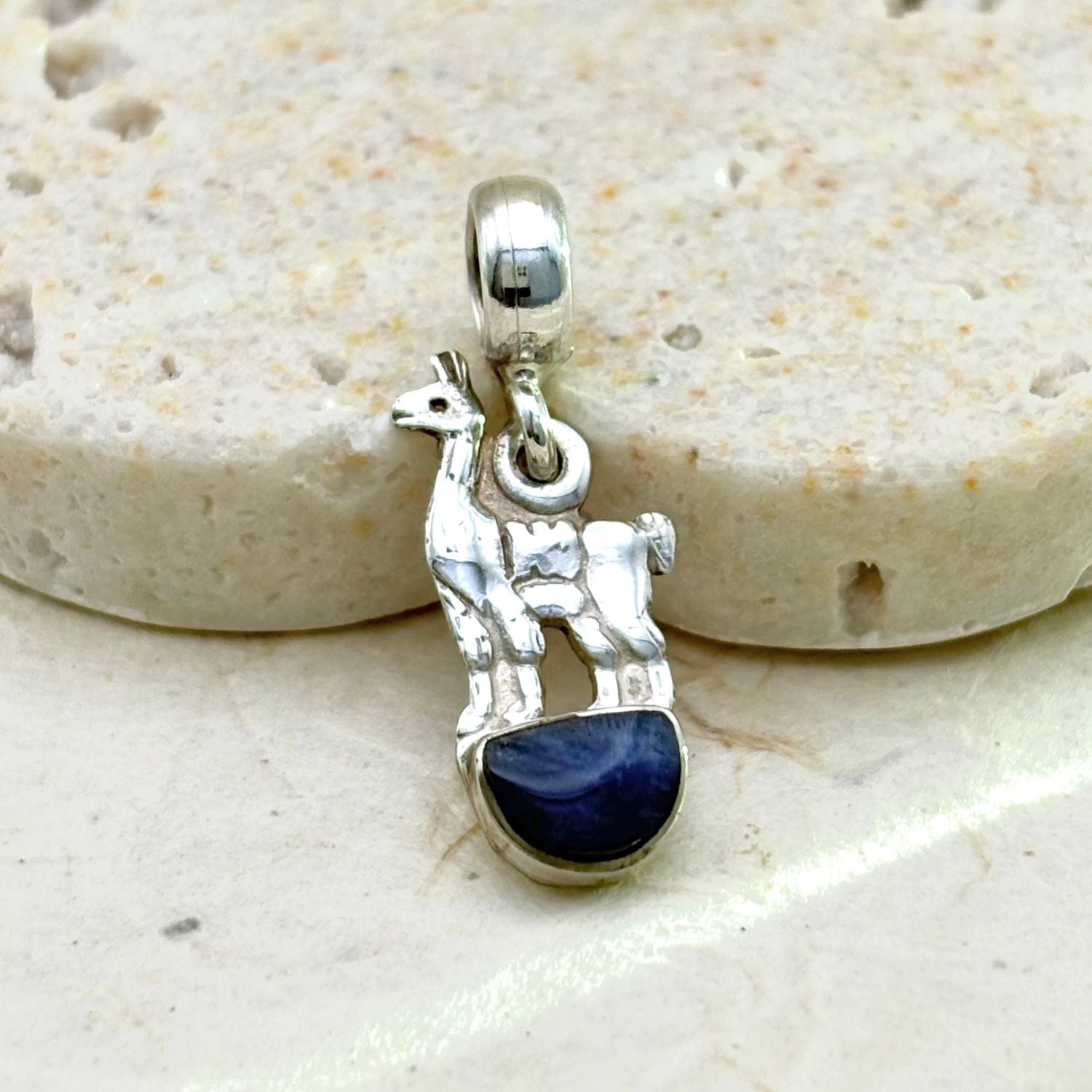 Vue rapprochée du pendentif Lama en argent mettant en valeur le lapis-lazuli et les détails de la silhouette.