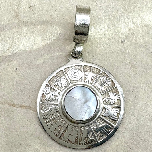 Vue rapprochée du pendentif Lumia mettant en valeur le centre en nacre et le motif gravé du bijou.