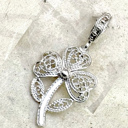 Vue rapprochée du pendentif Trèva mettant en valeur les détails du travail ajouré et les finitions artisanales.