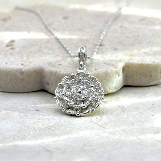 Pendentif Roséa en argent en forme de fleur aux reliefs finement travaillés, collection Essentielle.